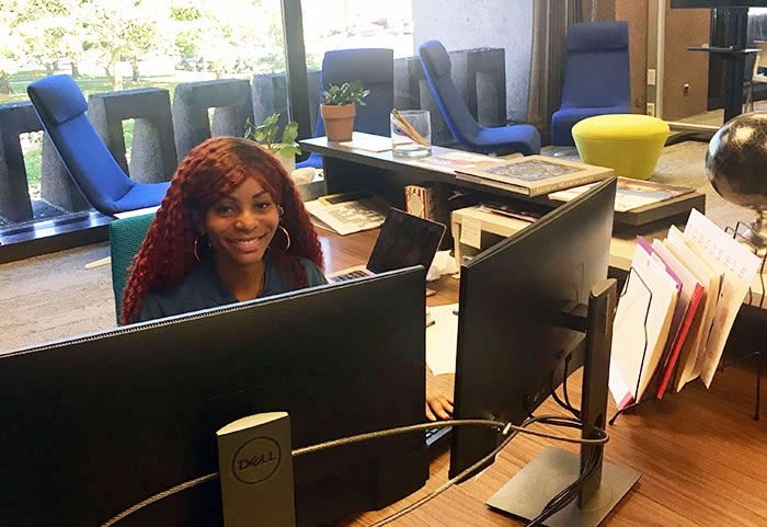 SOURCE staff at desk working on computer.